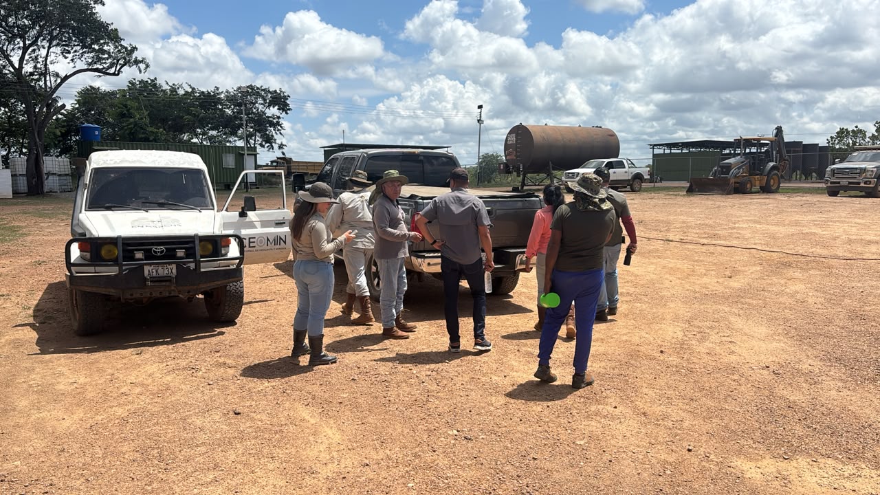 Equipo técnico reunido en campo junto a vehículos e infraestructura