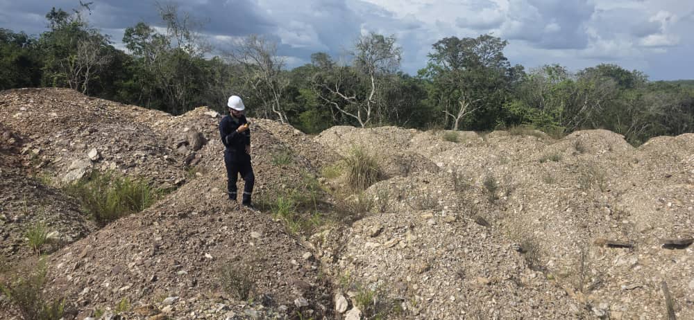 Supervisor con casco y overol en montículo de material excavado